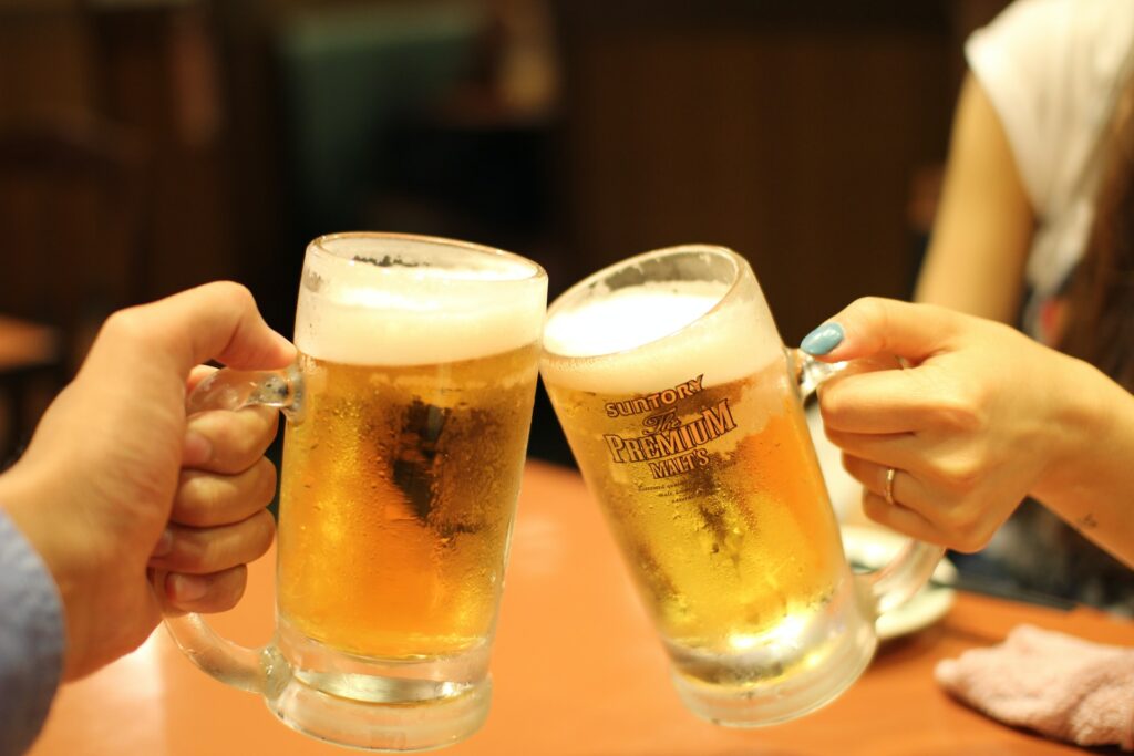 Two hands holding beer mugs in the 'cheers' fashion