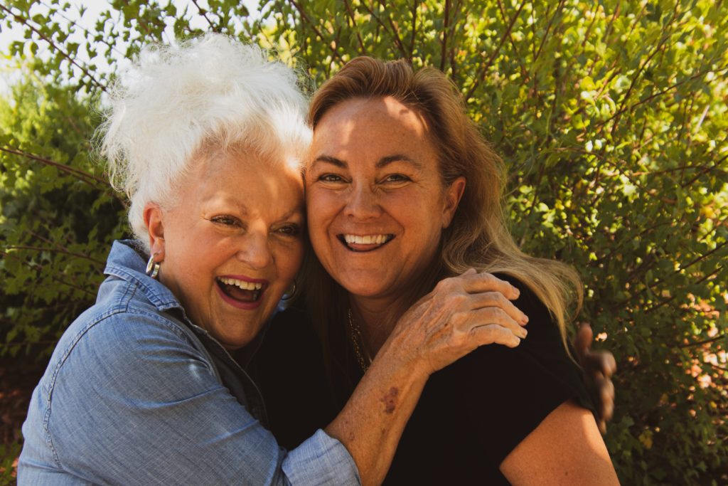 Two women in senior social groups smiling and enjoying each other's company