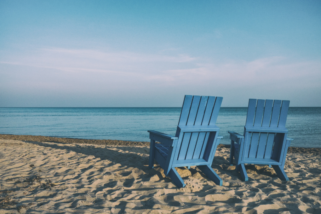 Two blue beach chairs on a sandy beach: Things to consider before retiring