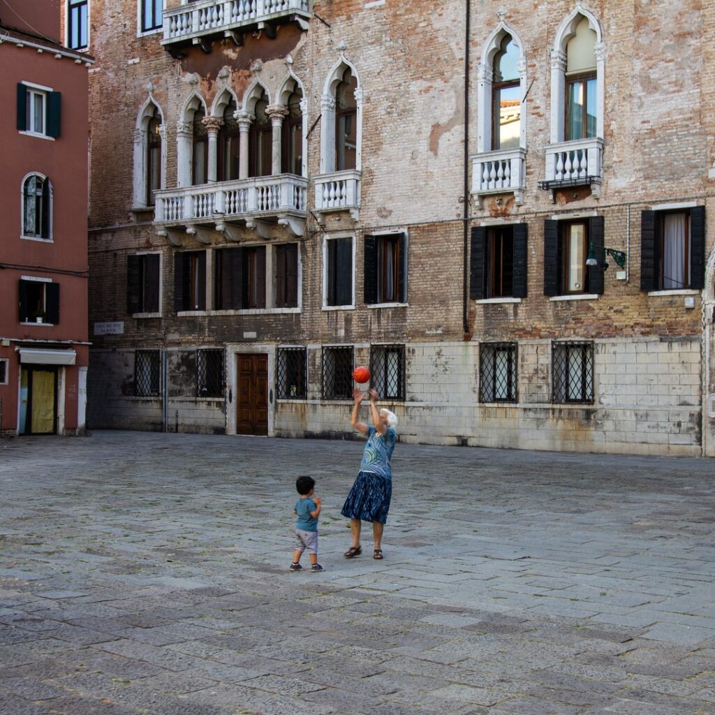 Older woman socially active with a child playing with ball.