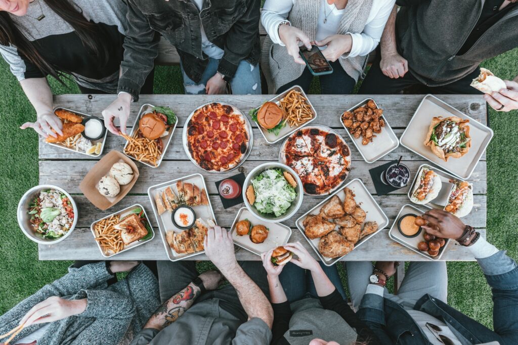 View from above of a table full of delicious food with people seated ready to eat