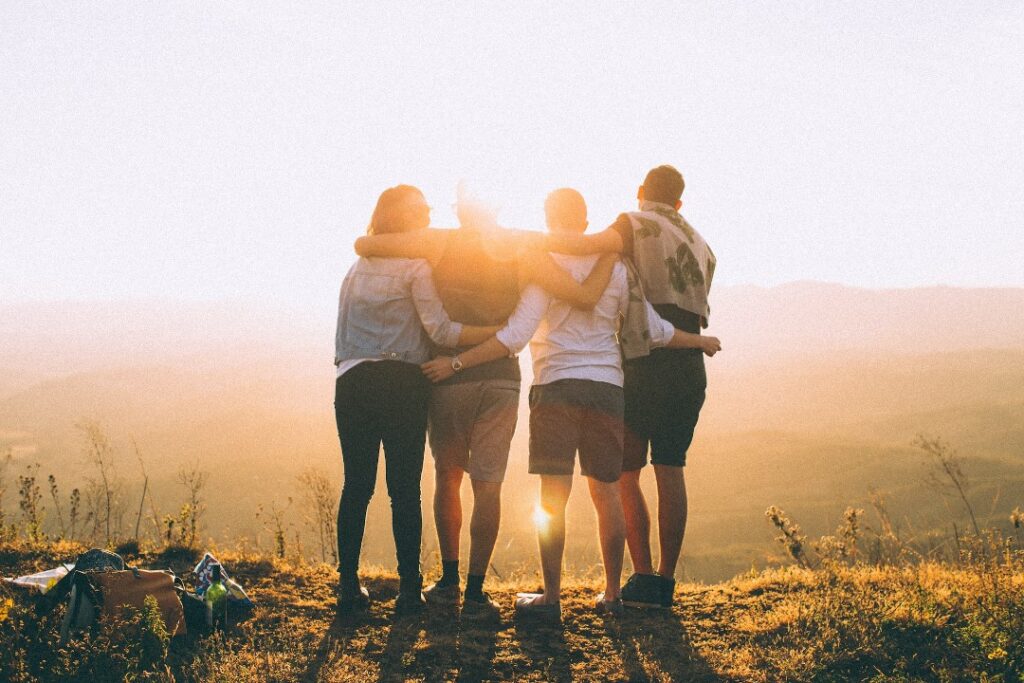Friends arm-in-arm silhouetted by the sun like Mytime dating with senior events