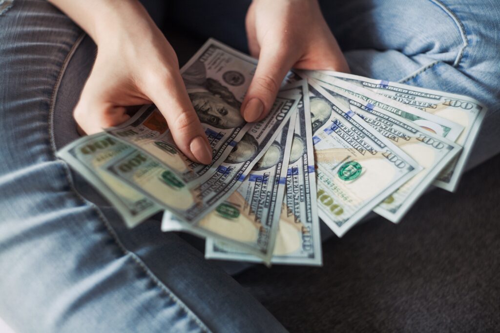 A person holding cash fanned out in their hands