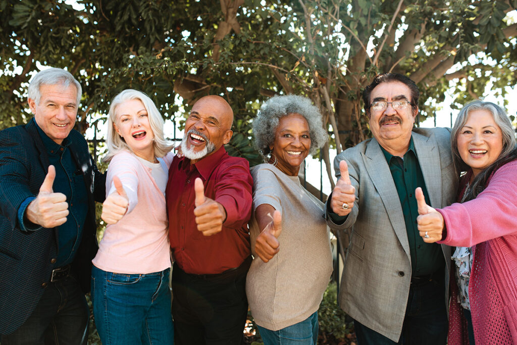 Group of older adults showing thumbs up